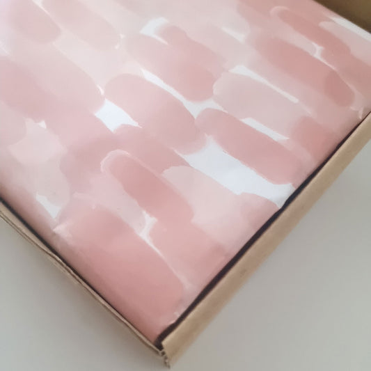 Watercolor paint strokes printed in pink ink on 30gsm white Tissue Paper in a kraft shipper box