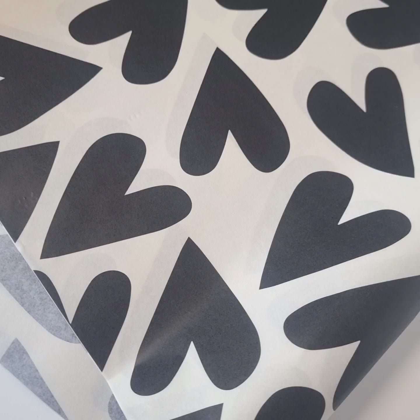 Video showing Printed tissue paper with Large hearts printed in black ink on a light beige background on 30gsm white tissue paper.